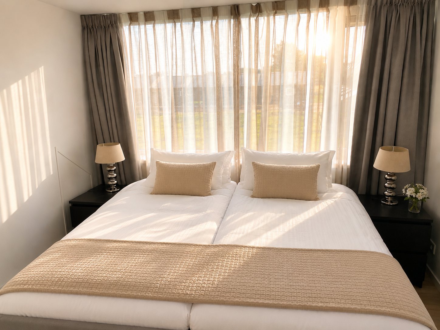 Slaapkamer met queensize bed en warme gordijnen